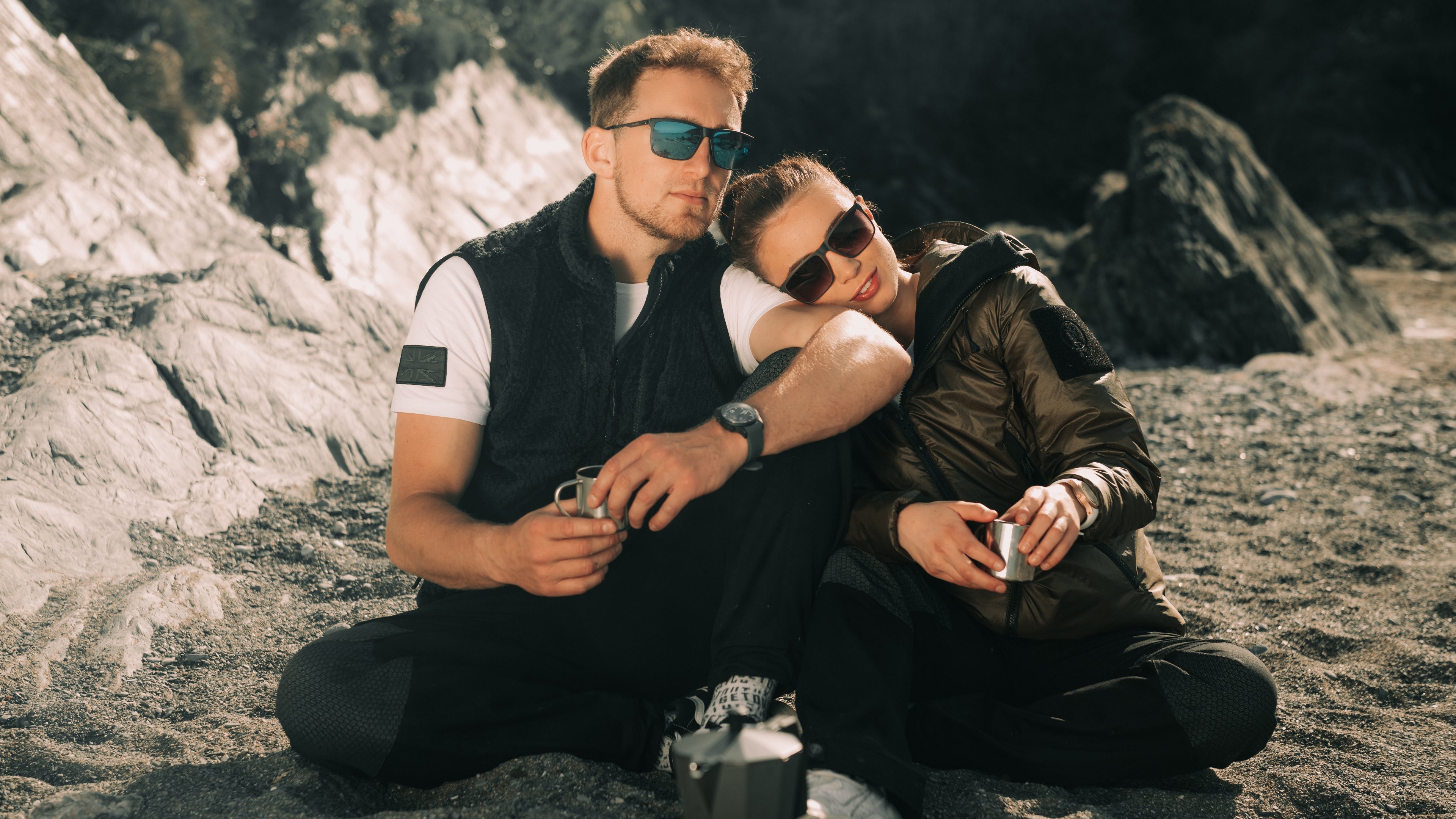designer sunglasses,couple sitting on beach